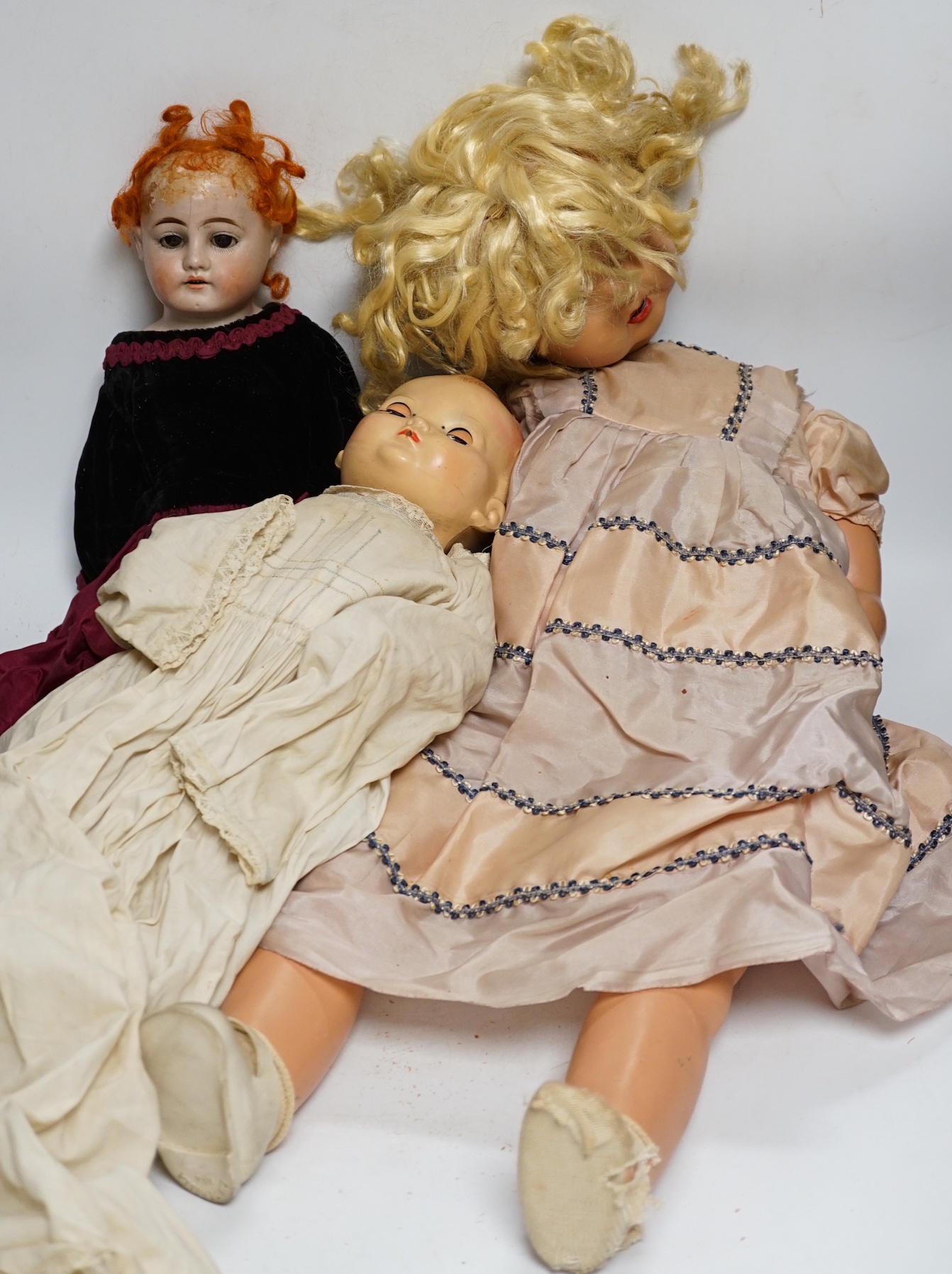 Three dolls; a German Bisque shoulder head doll with sleeping eyes with jointed kid leather body,