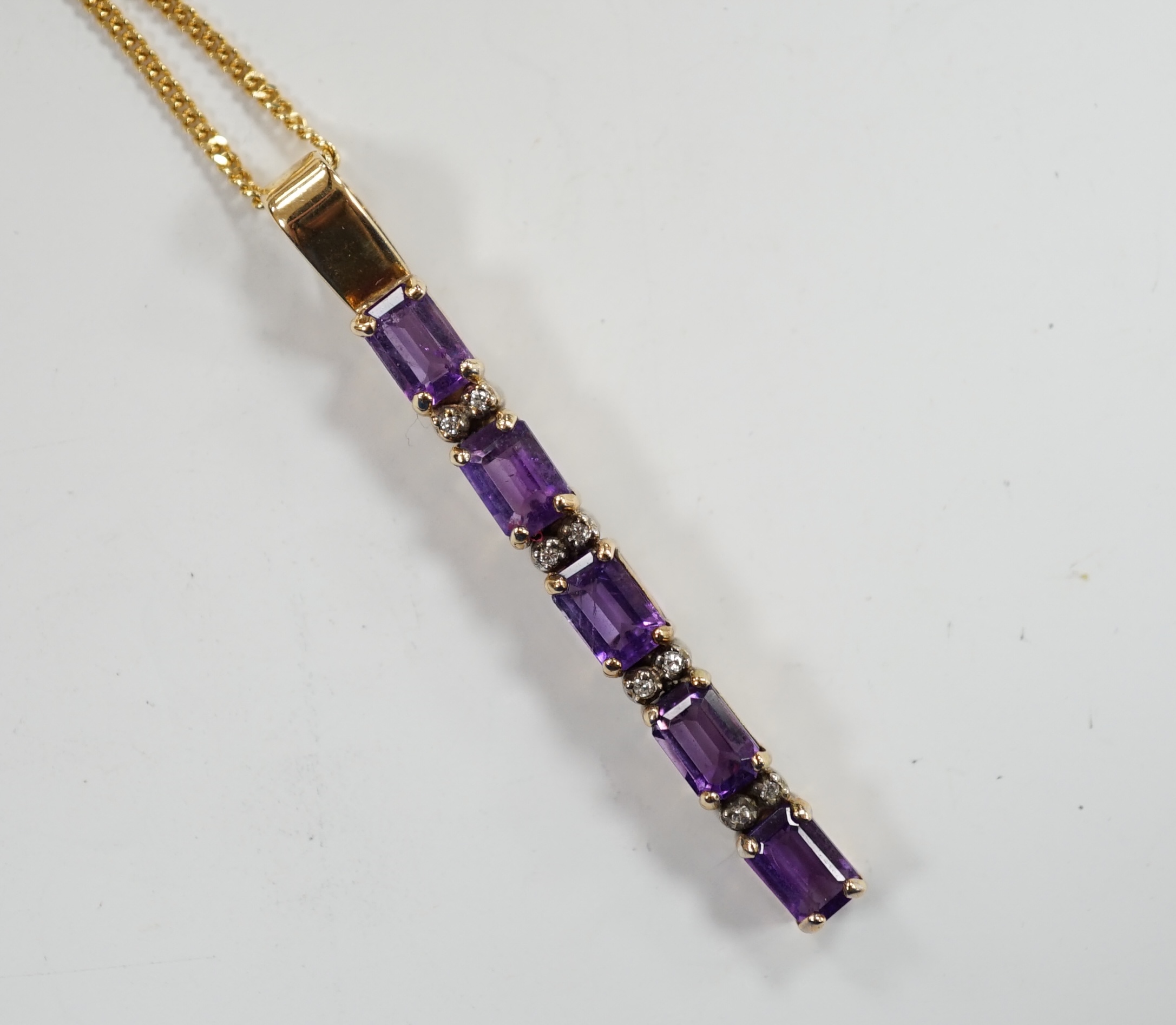 A modern yellow metal, amethyst and diamond chip set line pendant, 47mm, on an 18ct gold fine link