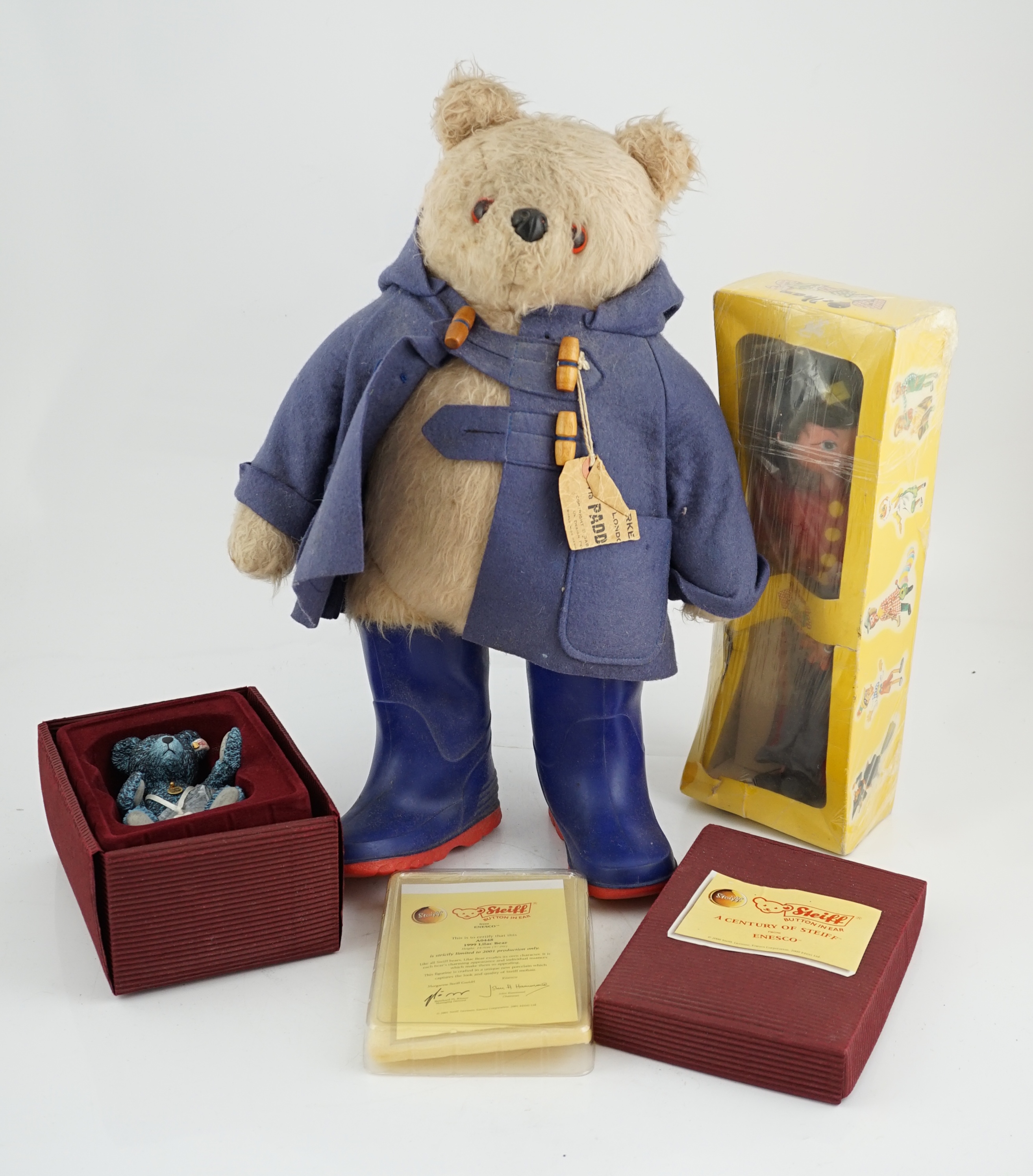 An early Paddington bear, blue jacket, missing hat, a Steiff Ltd. edition lilac bear in box, and a