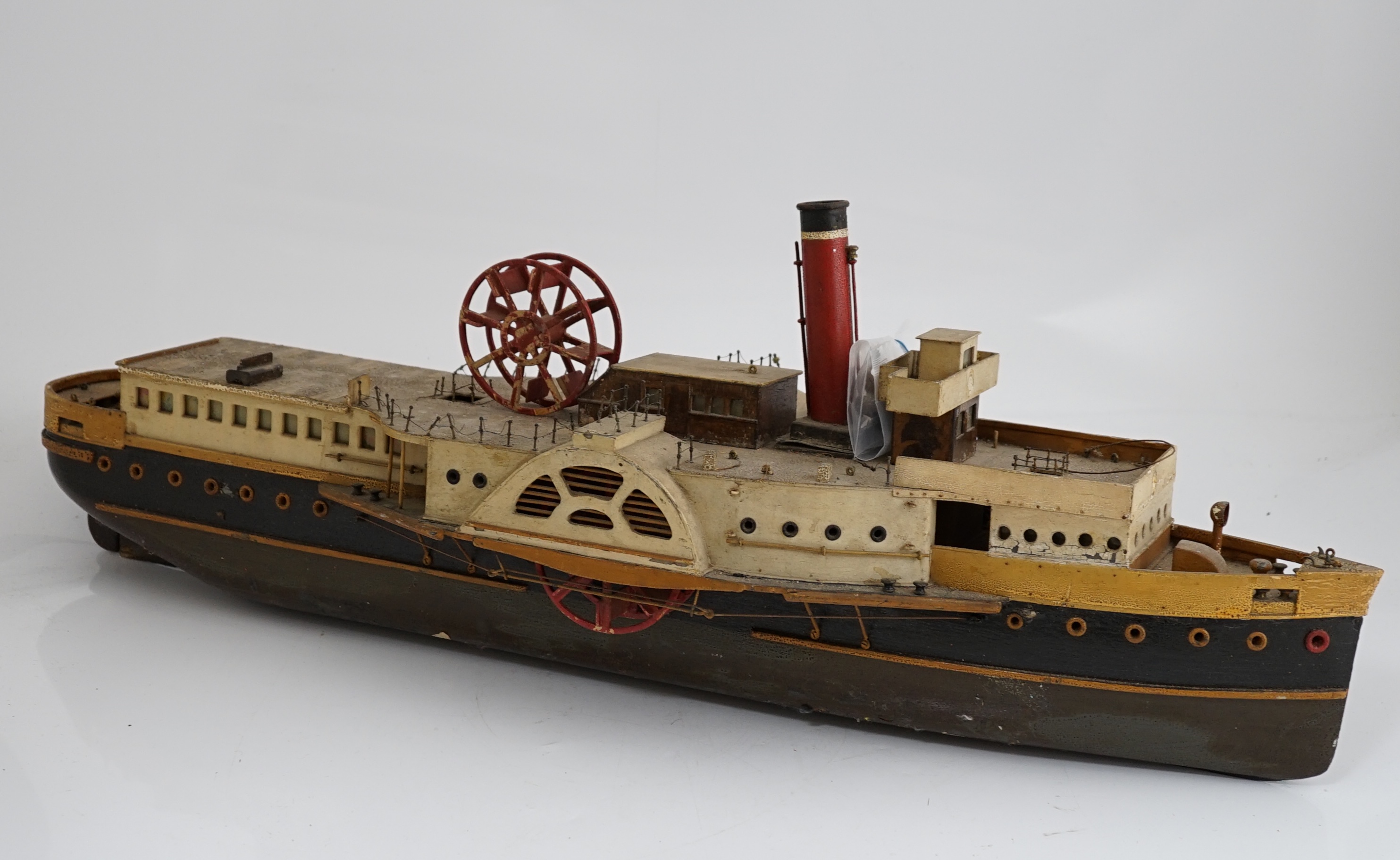 A wooden model of a paddle steamer, with a well detailed deck and with some age to the model,