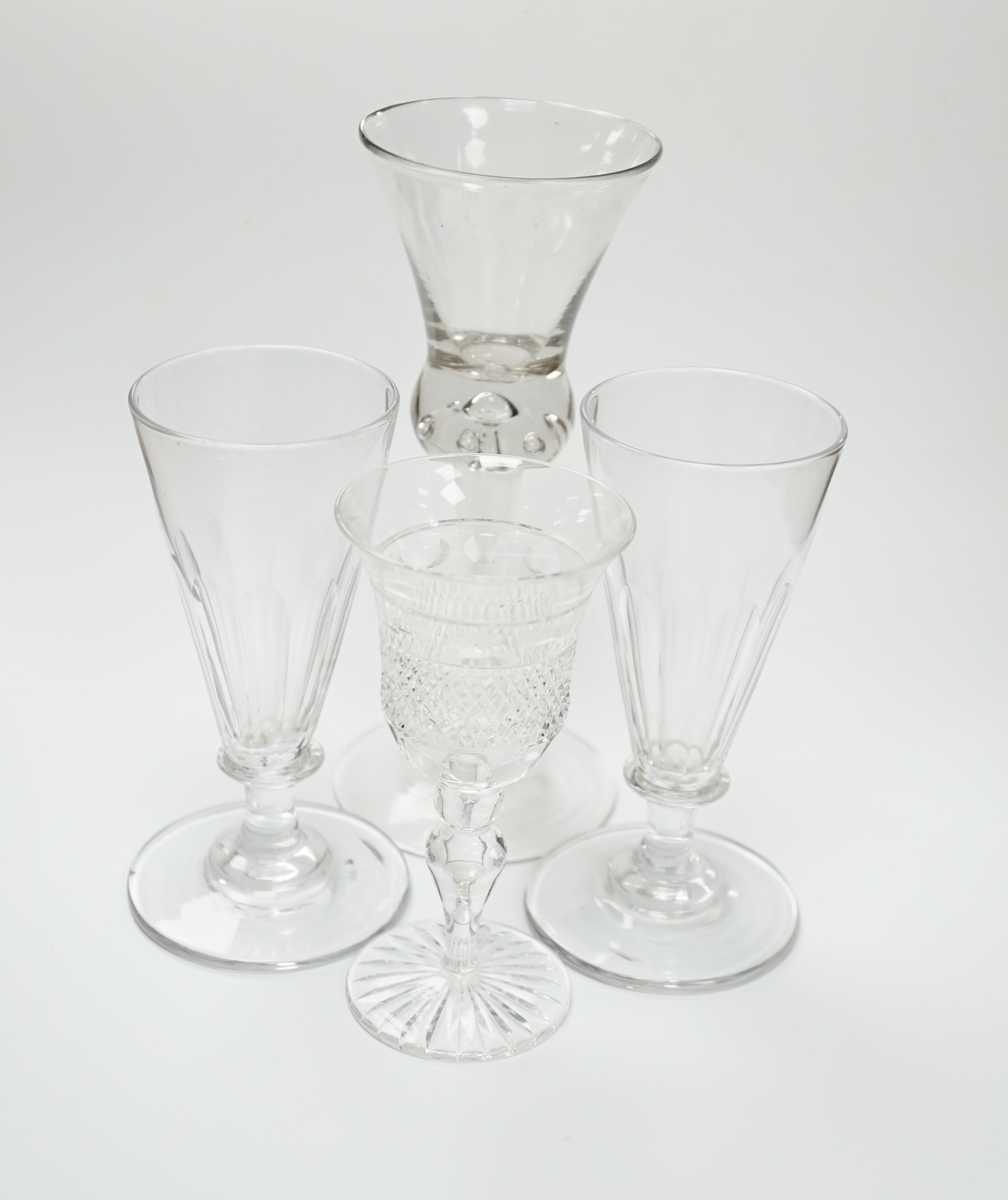 A pair of early 19th century dwarf ale glasses with fluted conical bowls, bladed knop stems and