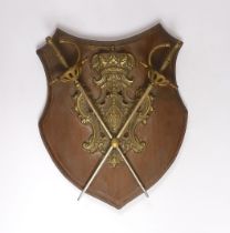 A wall mounting pine ‘shield’ with brass mounts and swords, 28cm