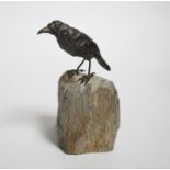 A cold painted bronze crow, raised on a stone base, 10cm high