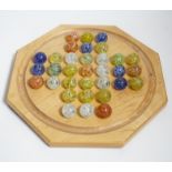 A turned wood solitaire board with multi-coloured glass marbles, 27cm wide