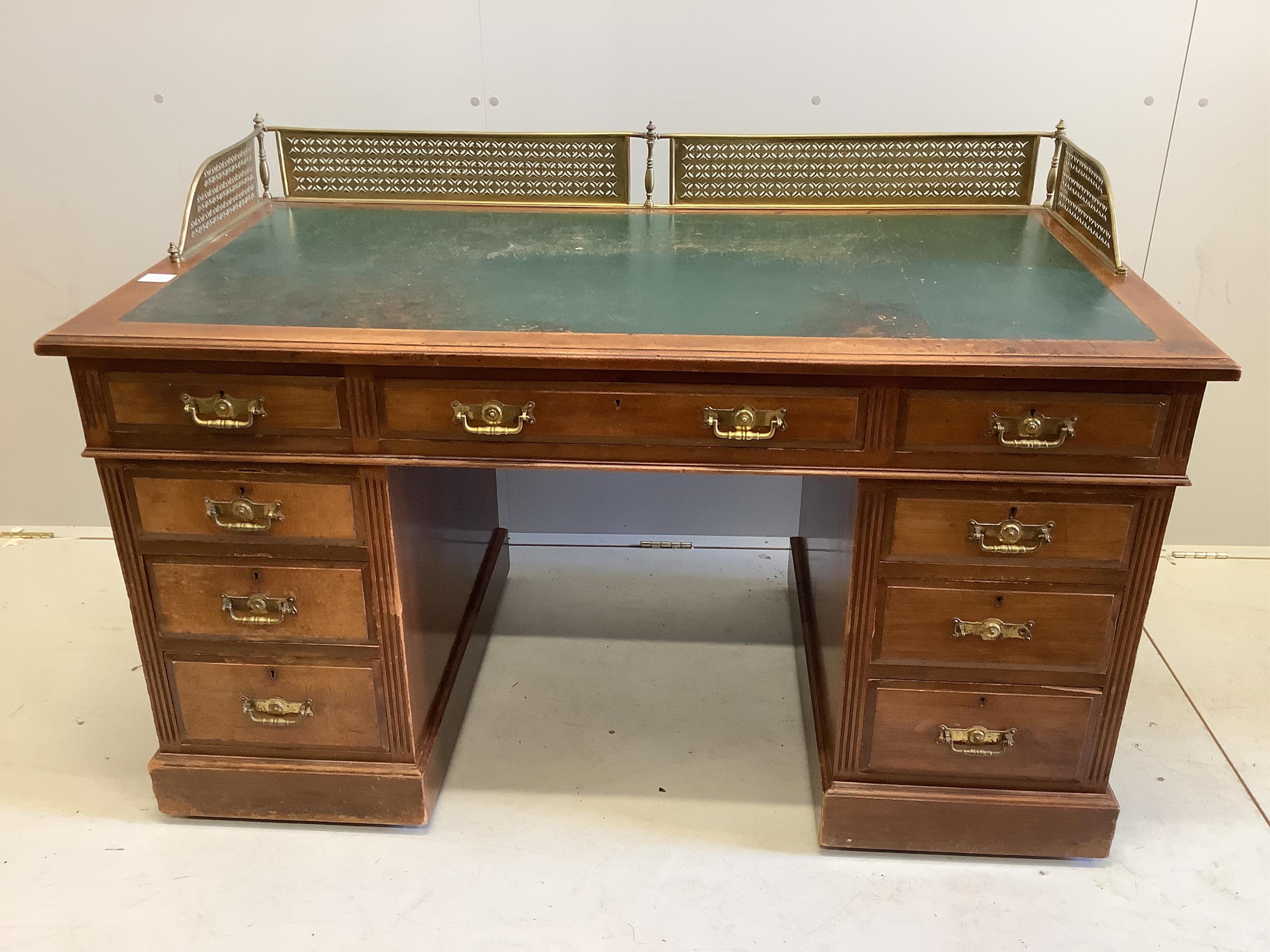 A late Victorian mahogany pedestal desk, fitted with pierced brass gallery, width 138cm, depth 73cm,