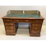 A late Victorian mahogany pedestal desk, fitted with pierced brass gallery, width 138cm, depth 73cm,