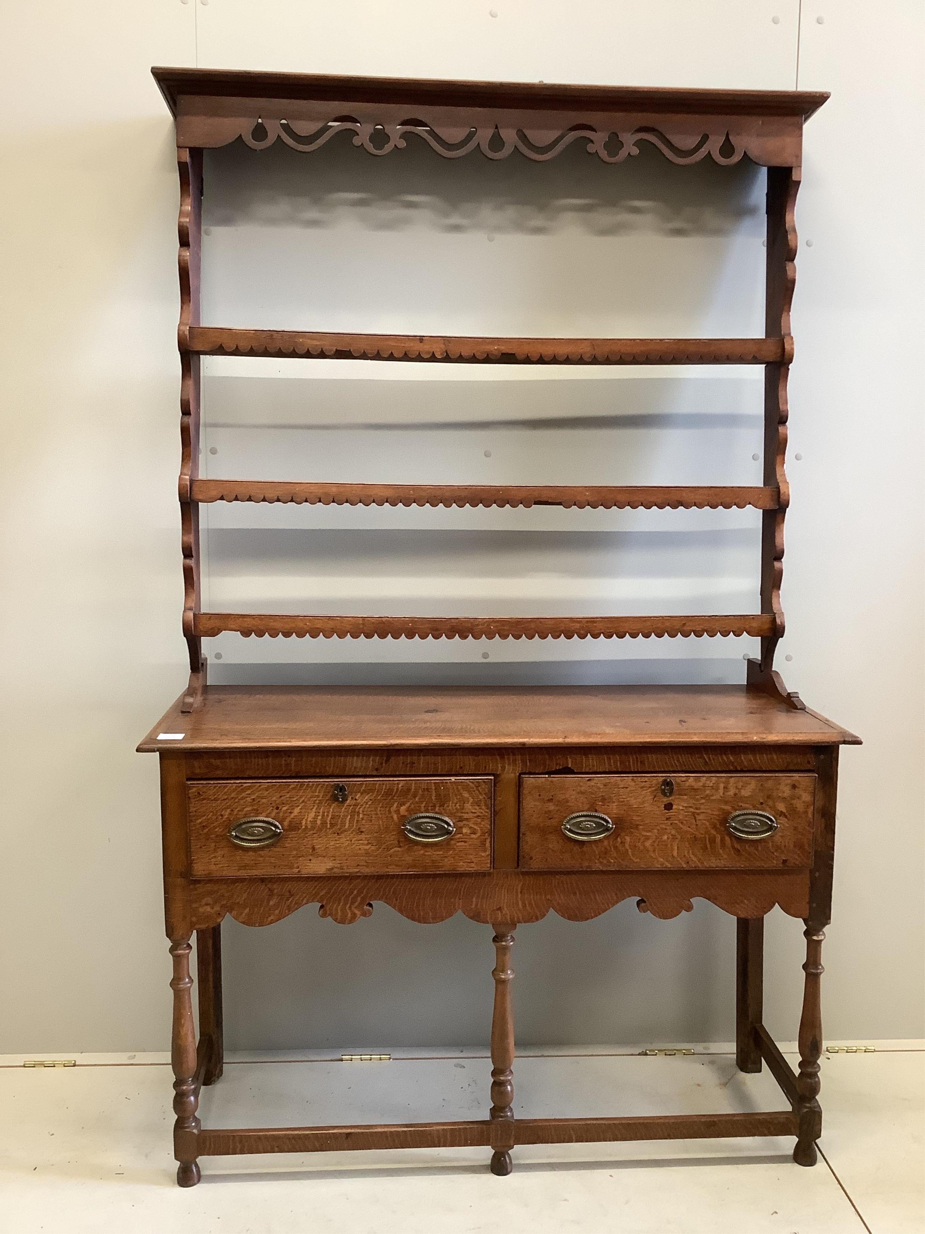 A George III style oak dresser, of small proportions, fitted with twin drawers and shaped apron,