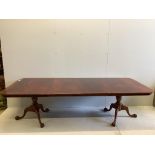 A Georgian style banded mahogany extending dining table, raised on twin turned supports and