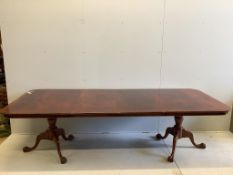 A Georgian style banded mahogany extending dining table, raised on twin turned supports and