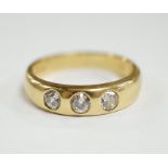 A modern 18ct gold and gypsy set three stone diamond ring, size R, gross weight 7.6 grams.