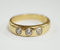 A modern 18ct gold and gypsy set three stone diamond ring, size R, gross weight 7.6 grams.