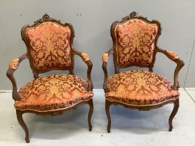 A pair of early 20th century French walnut upholstered open armchairs, width 63cm, depth 53cm,