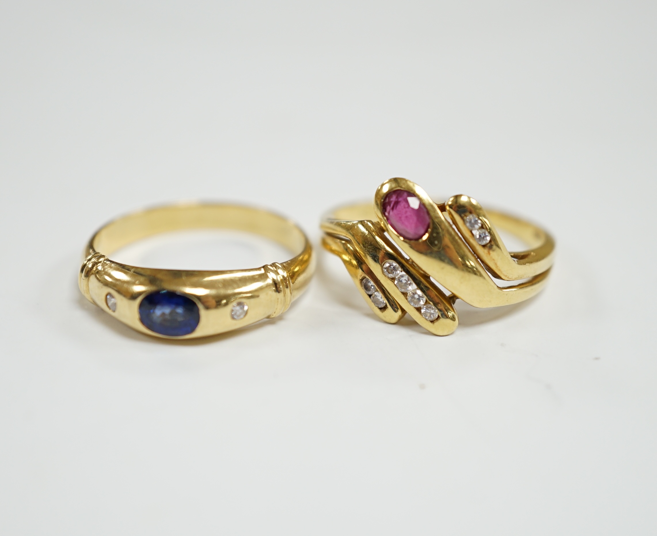 A modern 750 yellow metal and gypsy set single stone sapphire and two stone diamond set ring, size