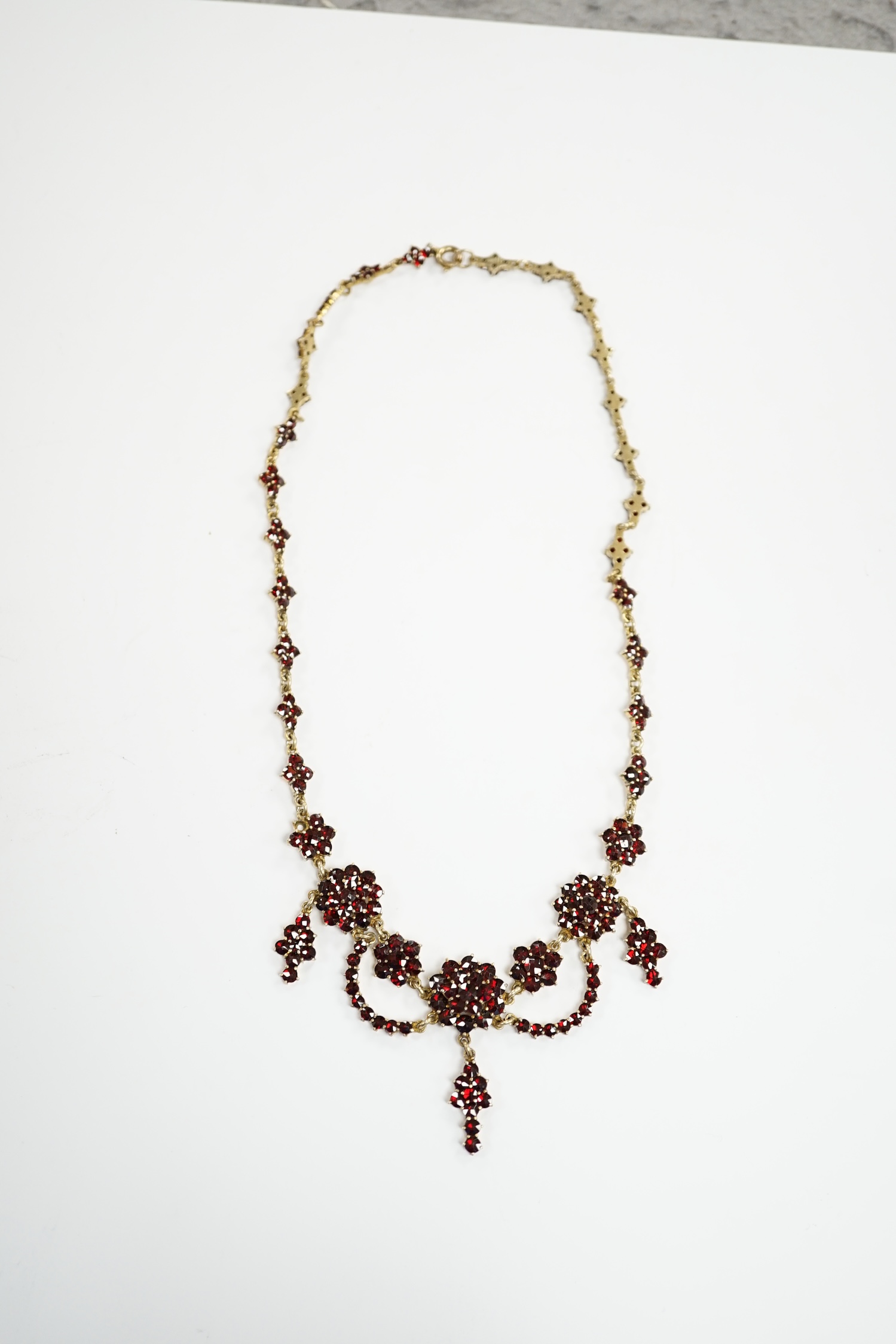 An early 20th century gilt sterling and garnet cluster set drop necklace, 45cm. - Image 2 of 5