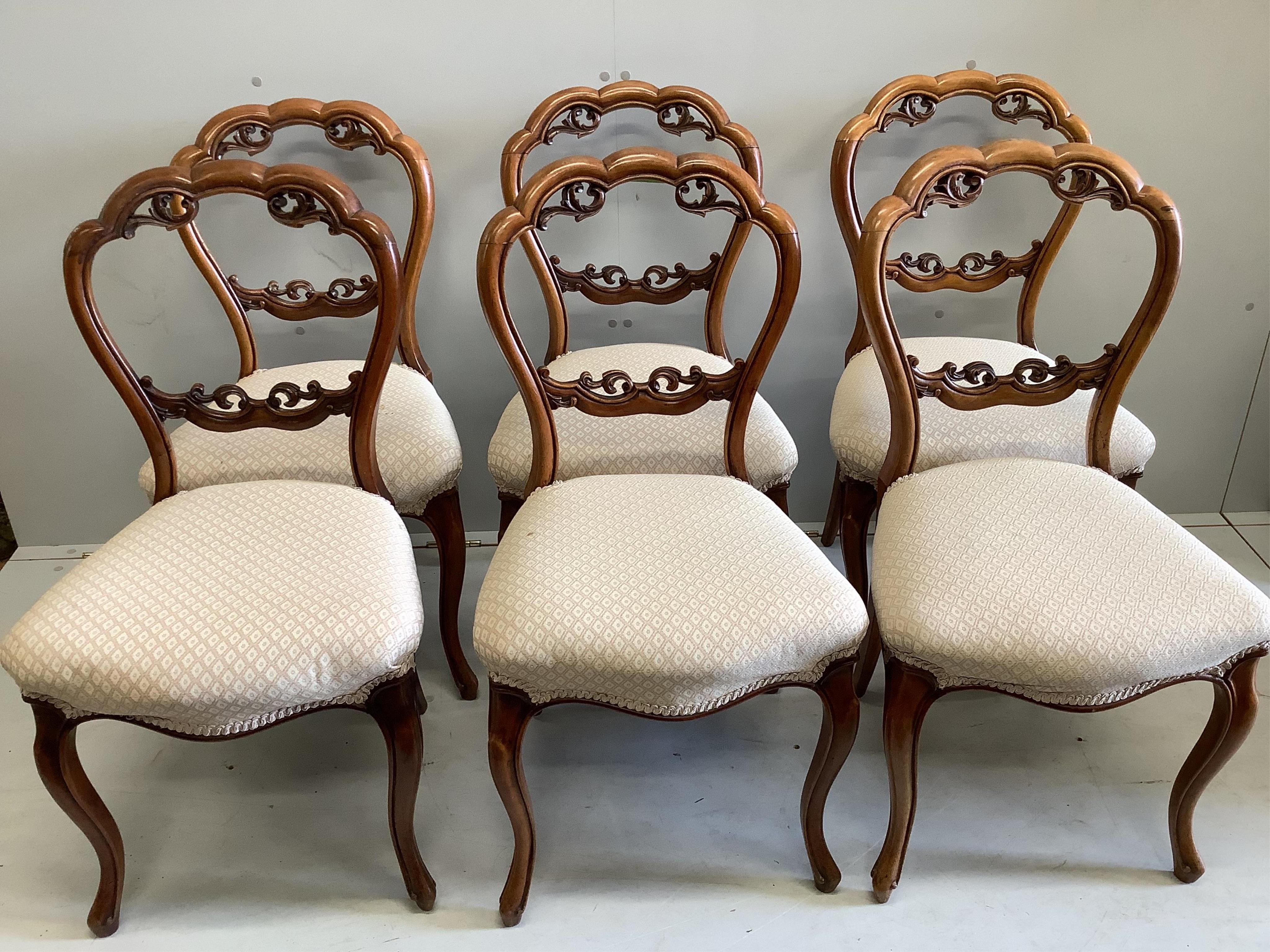 A set of six Victorian walnut balloon back dining chairs