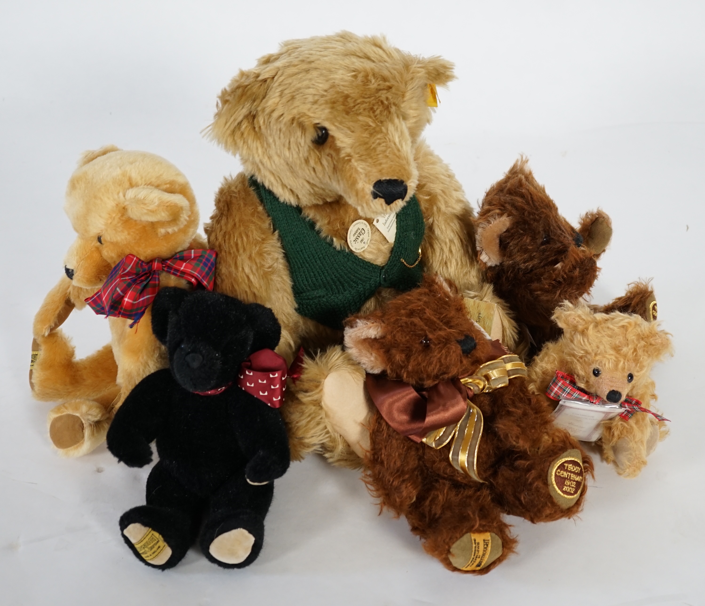 A large 1906 Steiff orange label, two Merrythought John Lewis bears, a black Merrythought bear, an