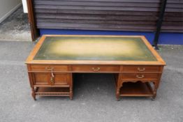 A late Victorian aesthetic movement walnut pedestal partner's desk with galleried undertier, by