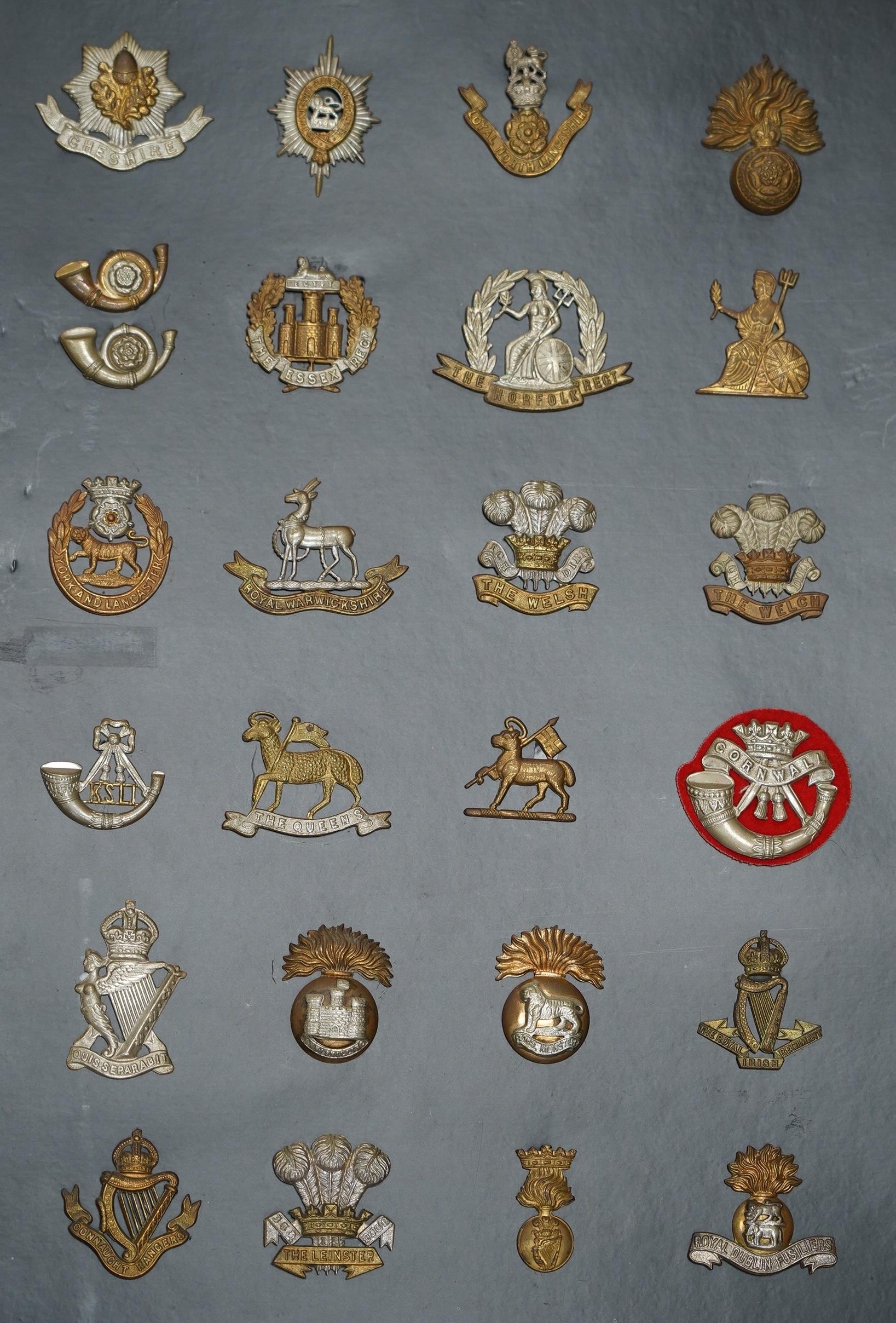 A collection of fifty-eight military cap badges, plus a few shoulder titles, mounted on four - Image 4 of 5