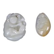 A late 19th / early 20th century Chinese carved jade pendant and a later example, largest 5cm.