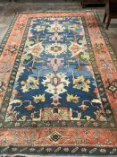 A Caucasian style polychrome carpet, with a blue field and red geometric border, 390 x 236cm.