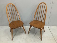 A pair of mid century Ercol elm and beech comb back dining chairs, height 96cm. Condition - fair