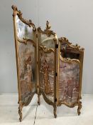 An early 20th century French carved giltwood three fold dressing screen with inset painted and