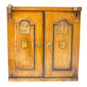 A Victorian oak cigar cabinet modelled as a safe, with brass coat of arms mounts, 30cm wide, 31cm