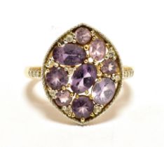 9CT GOLD AMETHYST COCKTAIL RING. The ring set with a millgrain white metal plaque decorated with