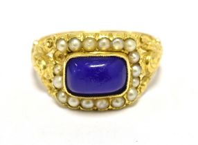 18CT GOLD, SEED PEARL AND BLUE STONE PANEL RING The ring with ornate scroll open work shoulders, the