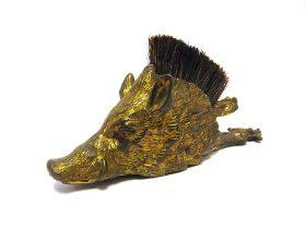 A VICTORIAN GILT BRASS LETTER CLIP in the form of a boar's head, with red glass eyes, the top fitted