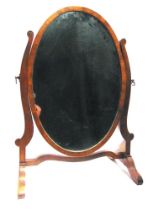 A MAHOGANY TOILET MIRROR with an oval glass plate, 55cm high.