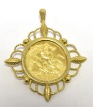 A 1982 HALF SOVEREIGN PENDANT Mounted in filagree yellow metal (worn markings to the bale. Total