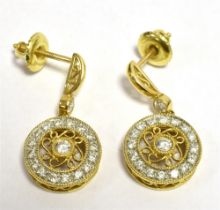 DIAMOND SET STUD EARRINGS The earrings in yellow metal with the post stamped 18k featuring a pendant