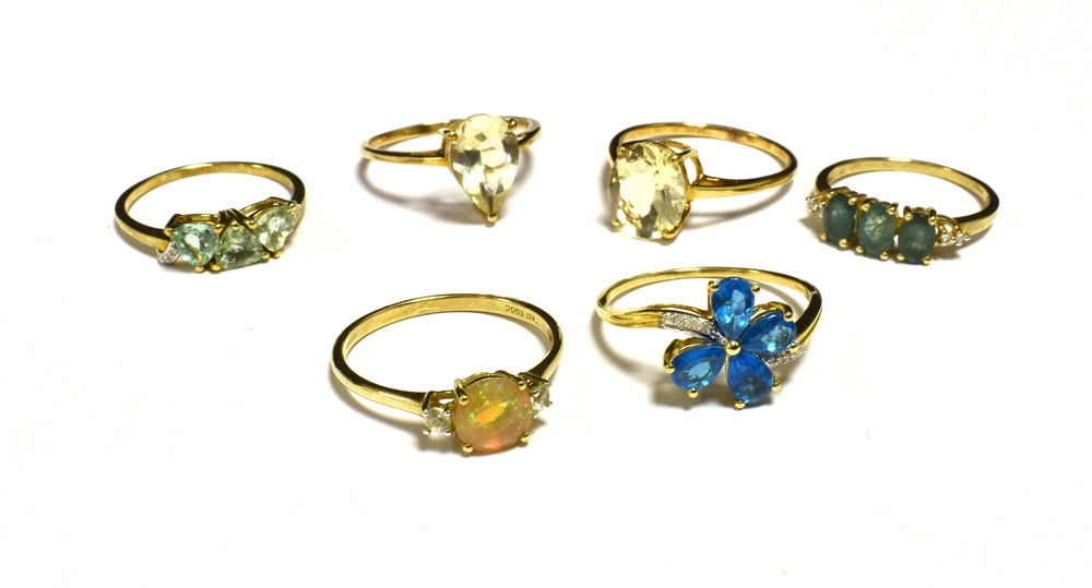 SIX DRESS AND COCKTAIL RINGS The rings set in coloured gem, stone and paste yellow metal shanks