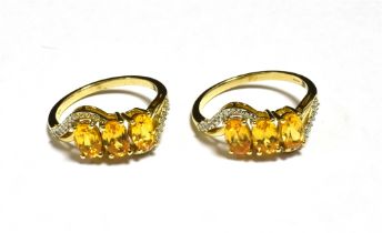 A PAIR OF 9CT GOLD ORANGE GARNET TRIPLE STONE DRESS RINGS Both rings with matched designs