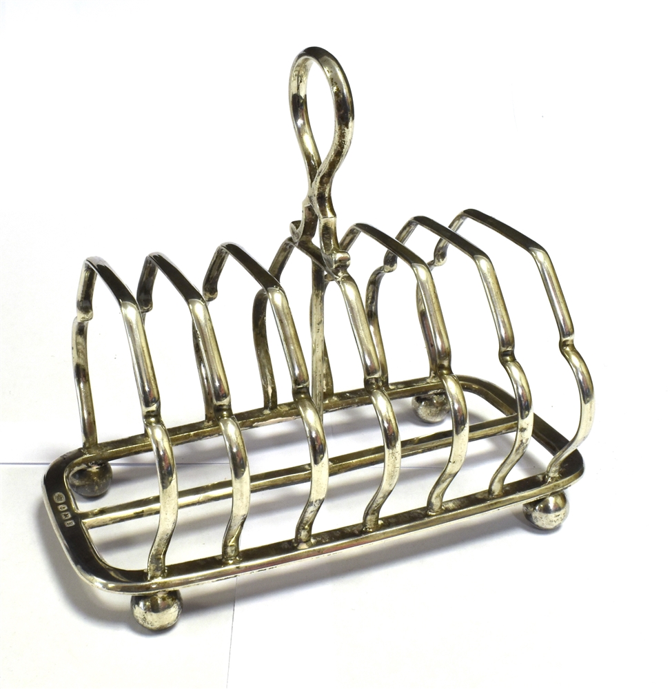 SILVER TOAST RACK On four ball feet length 14.5cm. Height including handle 13cm approx. Hallmarked