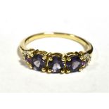 9KT GOLD, PURPLE SAPPHIRE THREE STONE DRESS RING The ring with diamond accent shoulders, ring size N