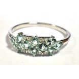 9KT WHITE GOLD AQUAMARINE CLUSTER RING. The ring set with 10 small round cut aquamarines with
