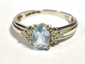 9CT WHITE GOLD SAPPHIRE AND DIAMOND DRESS RING The oval faceted light blue sapphire flanked by three