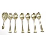 SILVER TEA CADDY SPOON together with six silver teaspoons, the caddy spoon with embossed figural