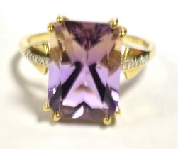 10K GEM SET COCKTAIL RING The ring set with a step cut purple gem measuring 15 x 10mm, Clear stone