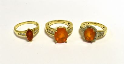 FIRE OPAL & DIAMOND DRESS RINGS One oval 12.3 x 10mm oval fire opal, flanked by round brillant and