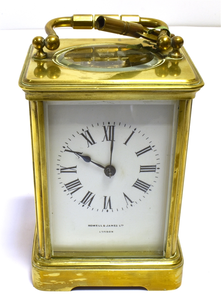 BRASS CARRIAGE CLOCK Retailed by Howell & James Ltd, London, stands 12cm tall, with five bevelled