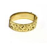 9CT GOLD METAL CORE BANGLE 18.7mm wide with foliate and scroll engraving to front, stamped '1/5th