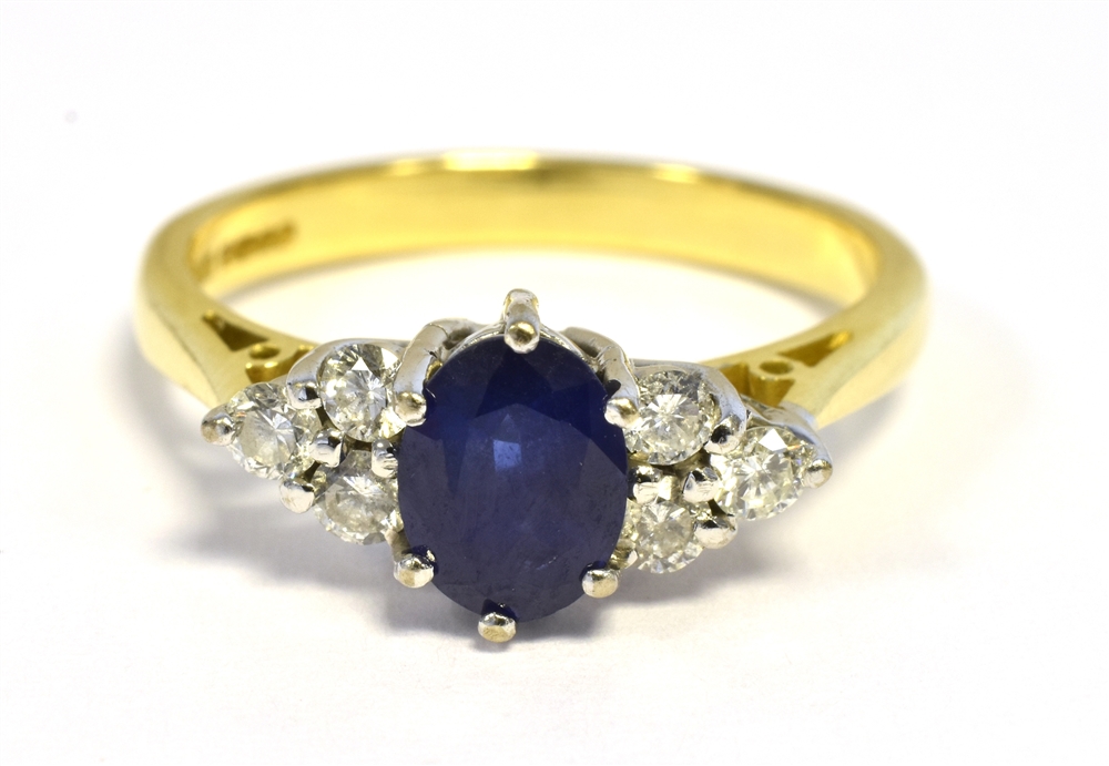 18CT GOLD SAPPHIRE & DIAMOND DRESS RING An oval violet blue sapphire of very good quality, estimated