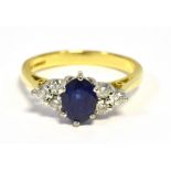 18CT GOLD SAPPHIRE & DIAMOND DRESS RING An oval violet blue sapphire of very good quality, estimated