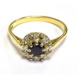 18CT SAPPHIRE & DIAMOND HALO RING Dark blue round cut sapphire, surrounded by a halo of grain set,