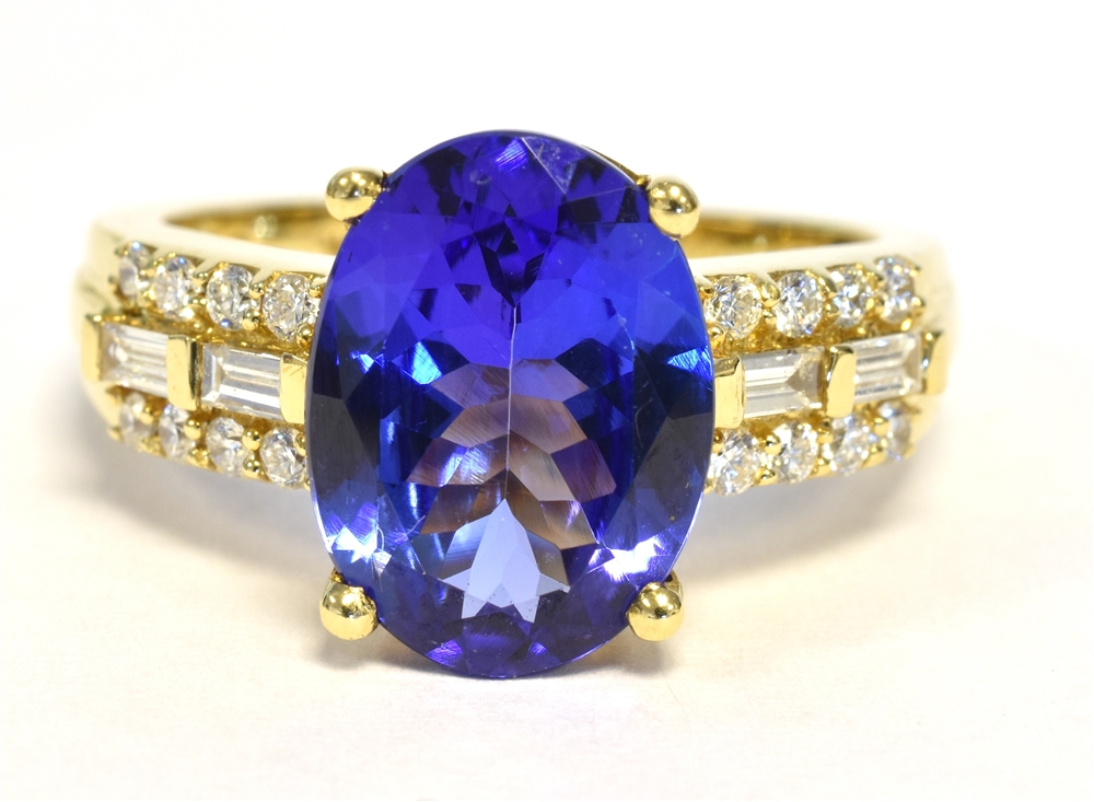 TANZANITE & DIAMOND DRESS RING Vivid oval tanzanite, approx 12.1 x 8.9mm, flanked by round brilliant