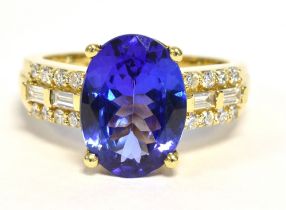 TANZANITE & DIAMOND DRESS RING Vivid oval tanzanite, approx 12.1 x 8.9mm, flanked by round brilliant