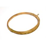 VICTORIAN ROSE GOLD BANGLE 9ct gold, oval in shape, with a scroll and foliate engraved front, push